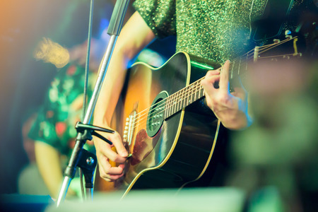 musician's hands playing guitar at a live show on stage, the concept of musical instrumentの写真素材