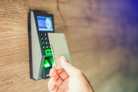 Door access control. Staff holding a key card to lock and unlock door at home or condominium. using...