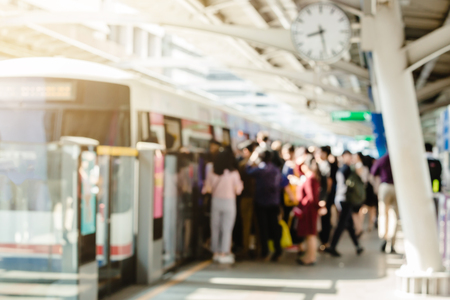 Blurry of people getting on and getting out electric skytrain with automatic gateway, railroad transportation for passenger in city, traveler and urban lifestyle.のeditorial素材