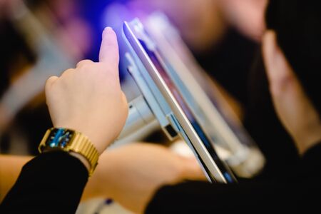 blurry hand and tablet for registration in to seminar event or meeting with  people background. blurry image for background. the concept of electronic registration.の写真素材