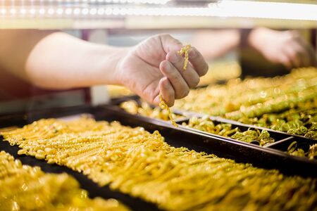 selective focus to hand holding gold jewelry, customers are buying gold jewelry in the gold shop at Yaowarat, Bangkok, Thailand.の写真素材