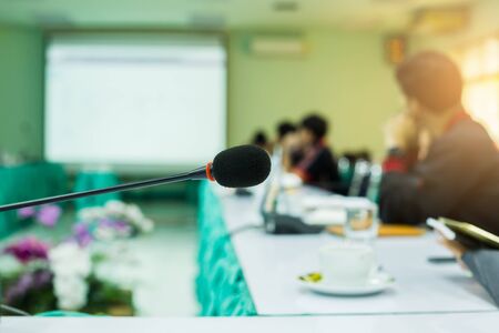 desktop wireless Conference microphones with blurry business group in a meeting room, microphone on the desk in meeting room with blurry people business background. the concept of speaking.の写真素材