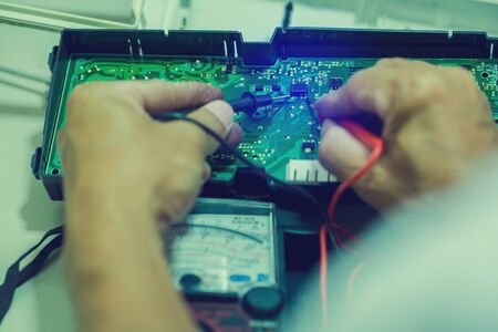 plumber repairing washing machine, man hands close up repair electronic device using Multimeter, man fixing domestic washing machine in the workshop, close up hands.の写真素材