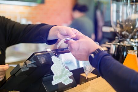 Cashier take banknote from consumer hand. Hand Paying Money To Worker In Coffee shop. Saleswoman...
