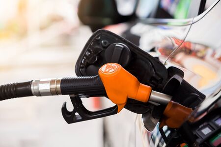 Refilling the black car with fuel at the gas station,  Refilling the car with fuel at the refuel...
