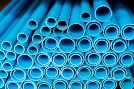 Close up to blue plastic pipe background, PVC pipes stacked in warehouse,  PVC water pipes used for...