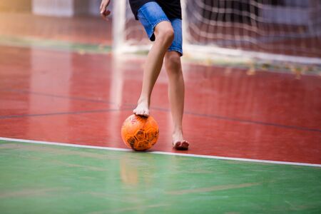 Futsal players barefoot. Futsal player  control and shoot ball to goal. Indoor soccer sports hall. Football futsal player, Orange ball, Futsal floor.の写真素材