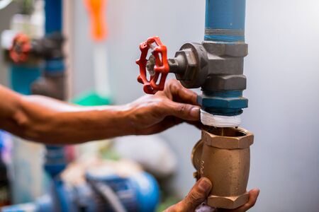 Plumber repair and remove the water supply pipe and valve. Plumbers working with blurry motor pump...