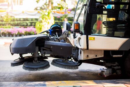 The special car cleans city road. Detail of a street sweeper machine. Car cleaning the road.