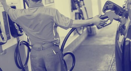 Selective focus to hands refilling the car with fuel and press control panel at the gas  station,...