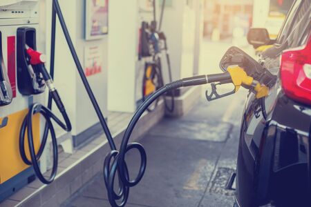 Refilling the car with fuel at the gas  station and blurry staff background,  refilling the car with fuel at the refuel station, the concept of fuel energy, Blurry image for background.の写真素材