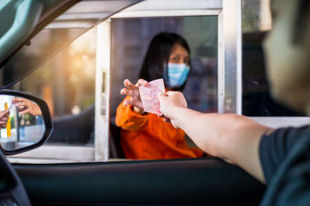 Bangkok , Thailand - March 23, 2020: Selective focus to driver pay for the expressway to woman staff...
