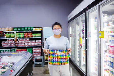 Bangkok, Thailand - March 29, 2020 : Asian women wear mask to prevent Coronavirus (Covid-19) and carry baskets for plastic saving programs in supermarket.のeditorial素材