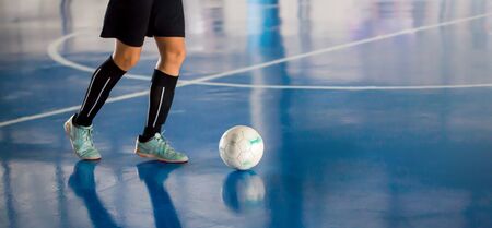 Futsal player control the ball for shoot to goal. Indoor soccer sports hall. Football futsal player, ball, futsal floor.の写真素材