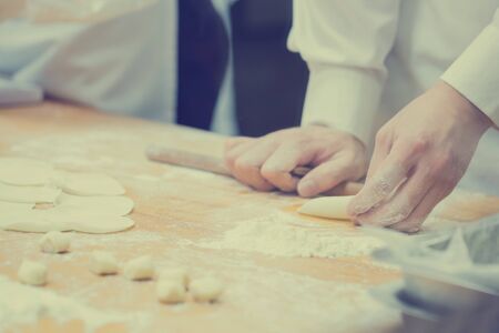 Chefs are cooking Chinese dumplings by the traditional bamboo steamers in a restaurant. Dim Sum chefs working wrapping dumplings at famous restaurant in Taiwan.の写真素材