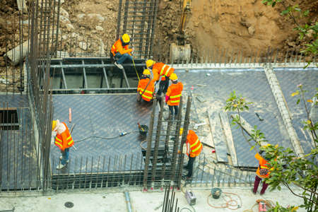 Bangkok Thailand June 18, 2021 : Construction workers are working on steel structures to prepare concrete floors at the construction site. Large scale high rise building construction project.のeditorial素材