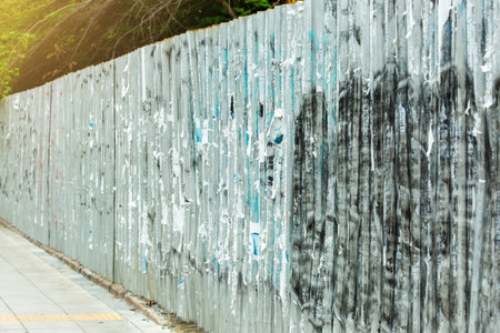 Selective focus to The galvanized wall fence was dirty from the bulletin board and scribbles.