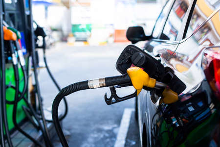 Refilling the car with fuel at the gas  station and blurry staff background,  refilling the car with fuel at the refuel station, the concept of fuel energy, Blurry image for background.の写真素材