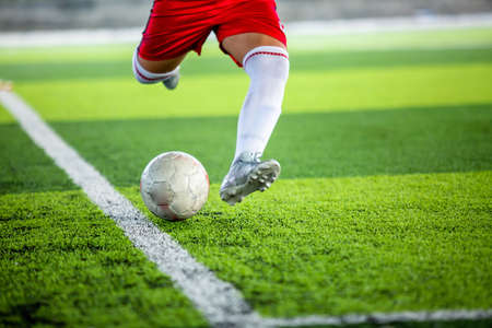 Selective focus to soccer ball with blurry soccer player run to shoot it. Shoot football background.の写真素材