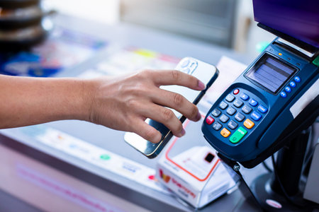 Selective focus to customer's hand is using mobile phone to scan to pay for service at counter...
