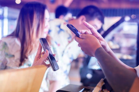 Selective focus to Customer hand using smart phone to scan Qr code payment tag  with blurry coffee...