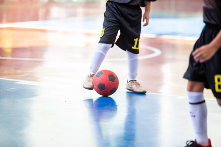 Kid futsal player control the ball for shoot to goal. Indoor soccer sports hall.の写真素材