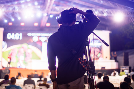 selective focus to cameraman with blurry video camera set are recording to speaker and audience in conference hall or seminar event. exhibition convention center. mass media concept.の写真素材