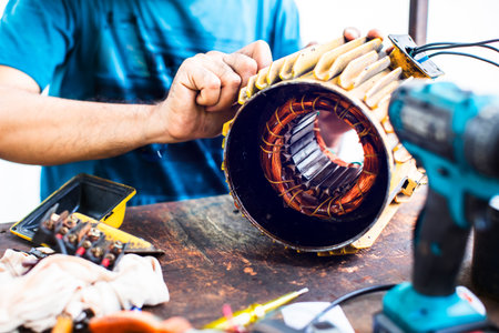 Copper windings inside an electric motor. The mechanic is repairing an electric motor by replacing the internal copper wire at Ban Mo, Bangkok, Thailand. Repair.の写真素材