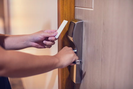 Selective focus to hand holding a key card to unlock door at home or condominium. Door access...
