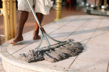 Housekeeper mopping the floor with a mop and cleaning products to clean dust. Cleaning dirty floor with mop.の写真素材