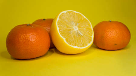 Sliced lemon and tangerine, on a yellow background. Citrus fruits.の写真素材