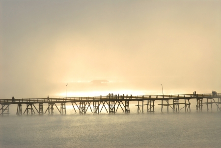 Silhouette of the wooden bridge in the mist Wooden bridge in the morning Bridge of the Mon village Sam pra sob river Sanbkhlaburi Kanchanaburi Thailand の写真素材