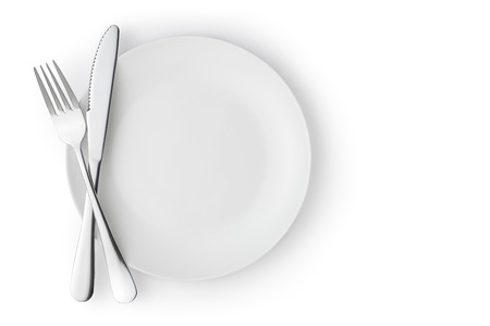 Fork and knife on a empty plate, Isolated on white.の写真素材