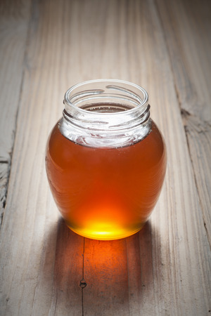 Honey in jar on the old woodの写真素材