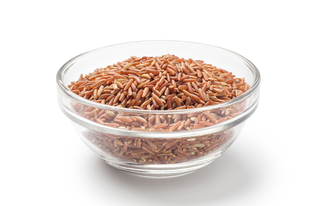 Red rice in a glass bowl on white backgroundの写真素材
