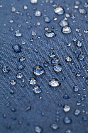 Drops of water on blue waterproof clothの写真素材