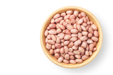 Raw peanuts in a wooden bowl on white background, Top view.