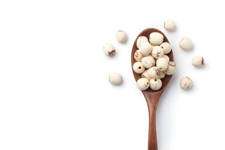 Dried lotus seeds in a wooden spoon isolated on white background. Top view.の写真素材
