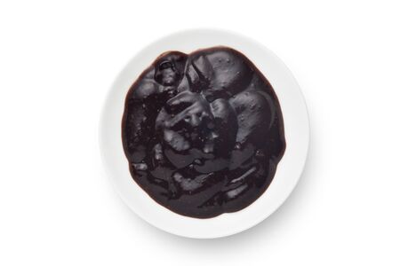 Black pepper sauce in a ceramics plate isolated on white background. Top view.の写真素材