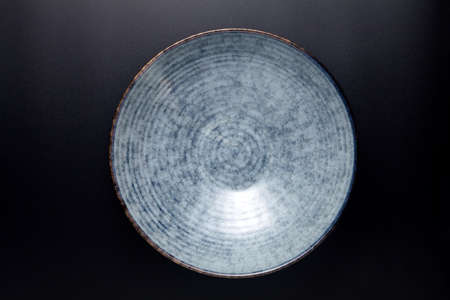 empty ceramic bowl on black background. top view.の写真素材