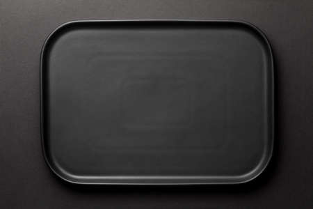 Top view of empty black plate on black backgroundの写真素材