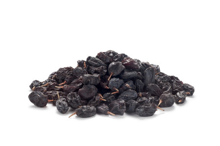 Pile of black currant raisins isolated on white backgroundの写真素材