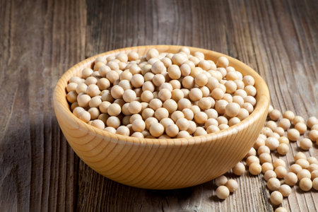 Soybean seeds in a wooden bowl on old wood.の写真素材