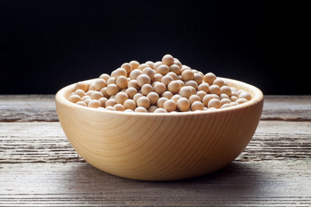 Soybean seeds in a wooden bowl on old wood.の写真素材