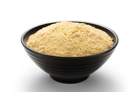 Corn flour in a black bowl isolated on white backgroundの写真素材
