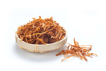 Shredded dried bamboo shoots in a basket isolated on white background.の写真素材