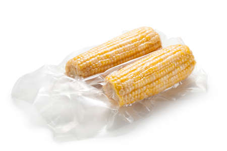 Corn cob in vacuum packaging on white backgroundの写真素材