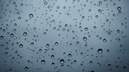 Water bubbles on the window with rainy skyの写真素材