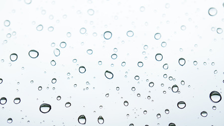 Water bubbles on the window with rainy skyの写真素材