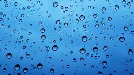 Water bubbles on the window with rainy skyの写真素材